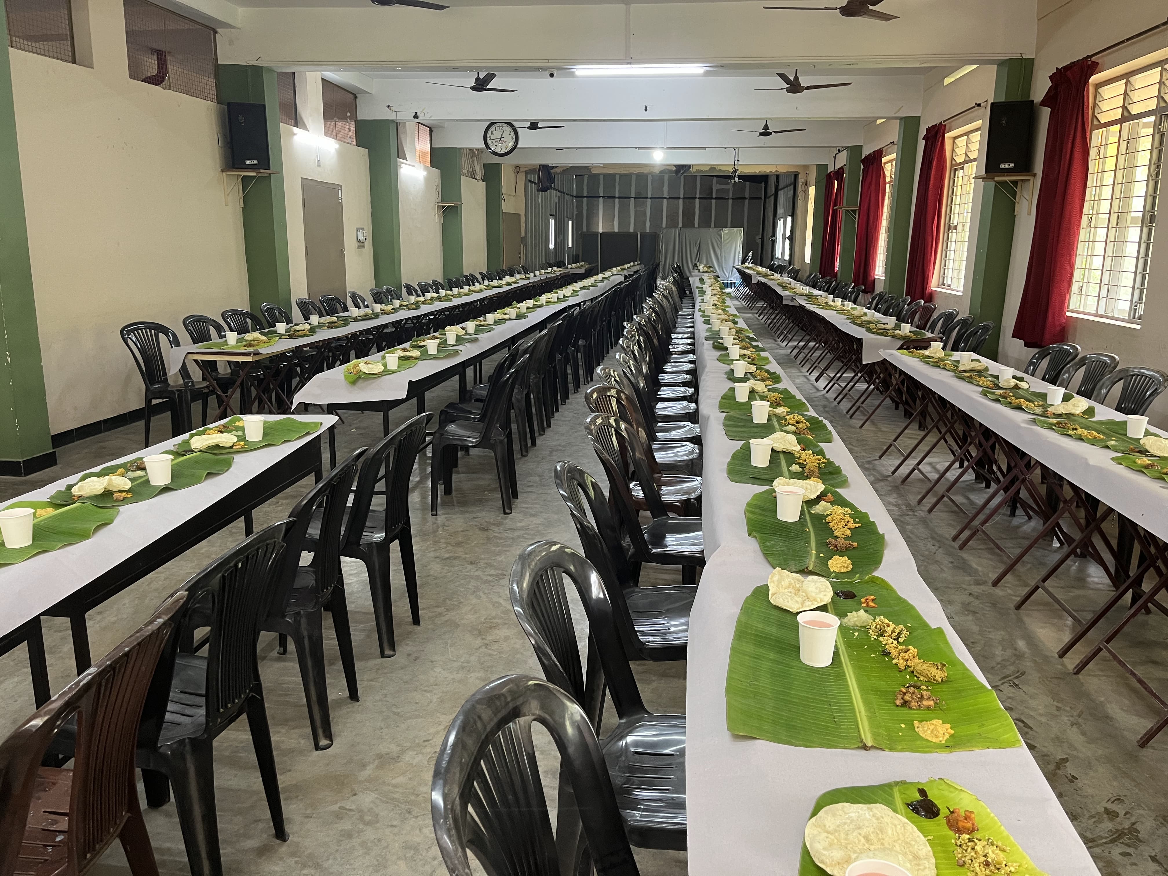 Dining hall tables prepared with banana leaves for sadhya